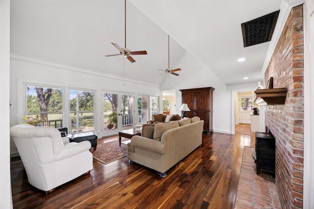 living room featuring a wood stove, high vaulted ceiling, ceiling fan, and dark wood-type flooring