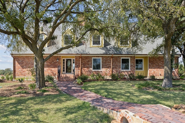 cape cod home featuring a front lawn