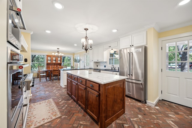 kitchen with pendant lighting, an inviting chandelier, appliances with stainless steel finishes, and plenty of natural light