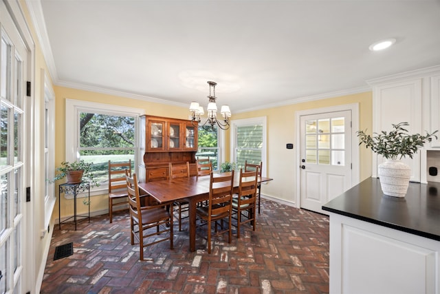 dining area featuring ornamental molding and a chandelier