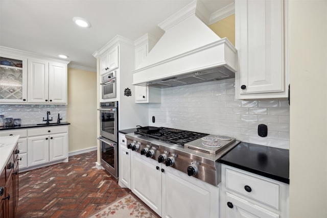 kitchen featuring white cabinets, custom range hood, and tasteful backsplash