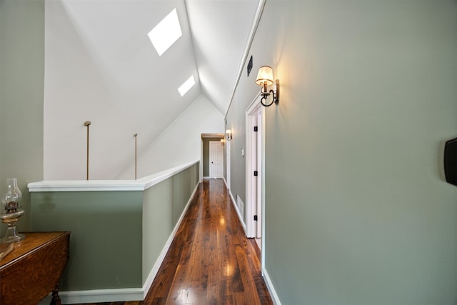 hallway featuring dark wood-type flooring and lofted ceiling with skylight