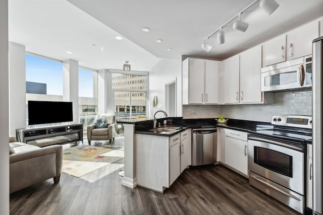 kitchen with white cabinets, sink, appliances with stainless steel finishes, and kitchen peninsula