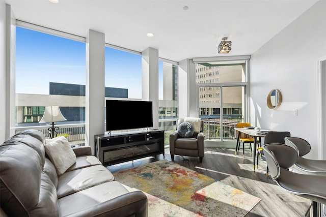 living room with a fireplace, floor to ceiling windows, and hardwood / wood-style floors