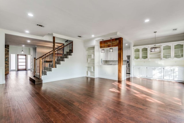 unfurnished living room with crown molding, dark wood-type flooring, and built in features