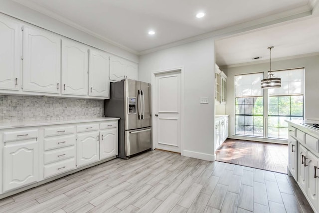 kitchen with stainless steel fridge with ice dispenser, white cabinetry, decorative light fixtures, and light hardwood / wood-style flooring