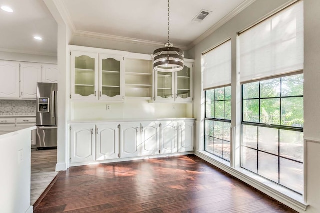 unfurnished dining area with dark hardwood / wood-style floors, a chandelier, and ornamental molding