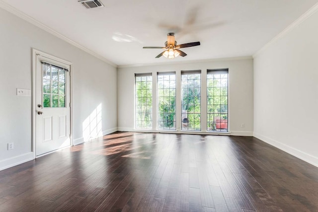 empty room with a healthy amount of sunlight, crown molding, and dark hardwood / wood-style floors