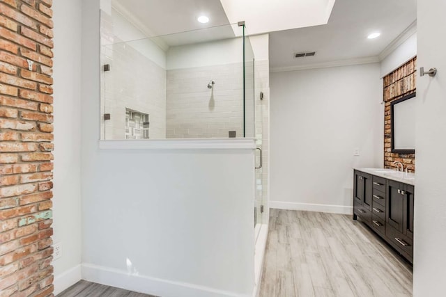 bathroom with ornamental molding, vanity, hardwood / wood-style floors, and an enclosed shower