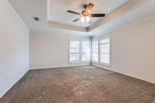 carpeted empty room featuring ornamental molding, ceiling fan, and a raised ceiling