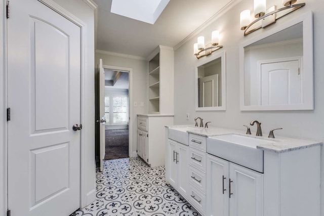 bathroom featuring a skylight, vanity, and ornamental molding