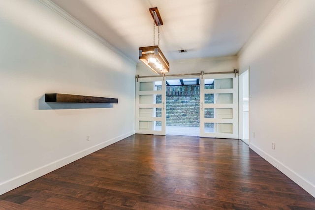 interior space featuring a barn door, dark hardwood / wood-style floors, and ornamental molding