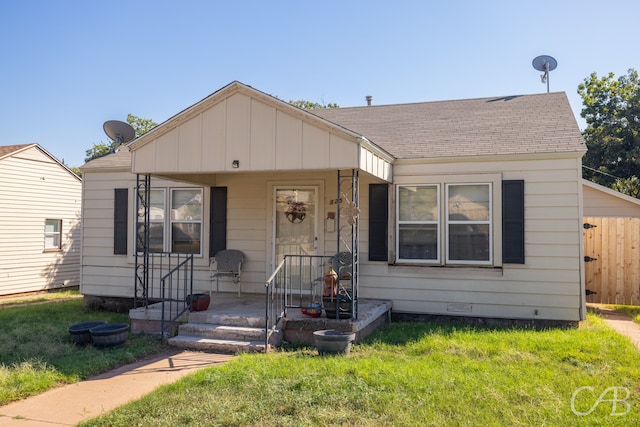 bungalow-style home with a front yard