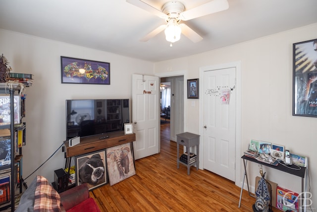 living room with crown molding, hardwood / wood-style floors, and ceiling fan