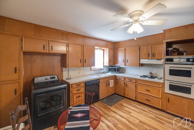 kitchen with washer / dryer, ceiling fan, white appliances, sink, and light hardwood / wood-style floors