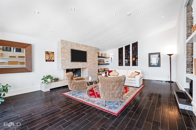 living room with a stone fireplace and dark hardwood / wood-style floors