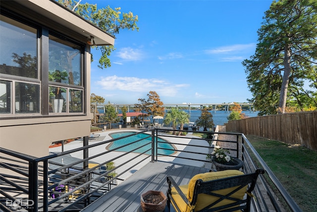 deck with a water view and a fenced in pool