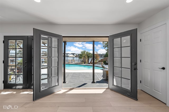 doorway with light hardwood / wood-style floors and french doors