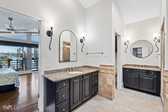 bathroom with vanity, ceiling fan, hardwood / wood-style flooring, and vaulted ceiling