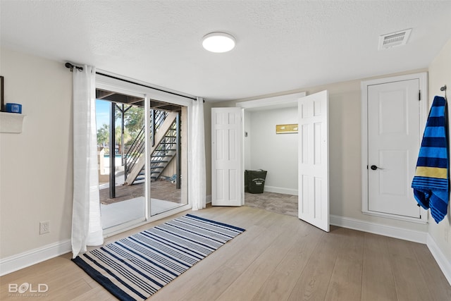 doorway featuring light hardwood / wood-style floors and a textured ceiling