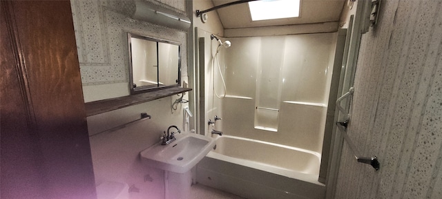 bathroom featuring sink,  shower combination, and vaulted ceiling