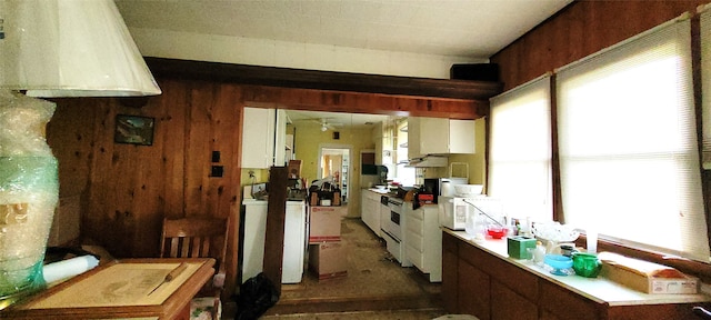 kitchen featuring washer / dryer, wood walls, extractor fan, and ceiling fan