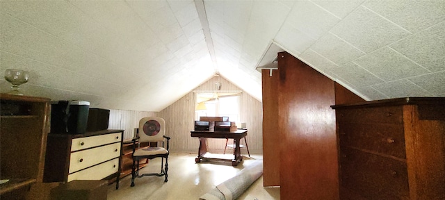 bonus room with wooden walls and vaulted ceiling