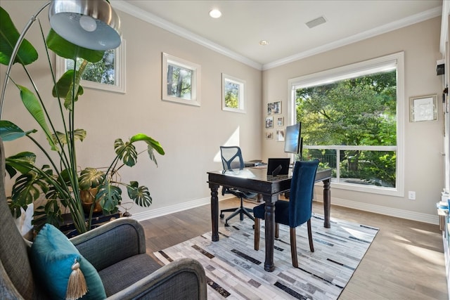 dining area featuring crown molding, a healthy amount of sunlight, and light hardwood / wood-style flooring