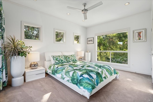 carpeted bedroom featuring crown molding and ceiling fan