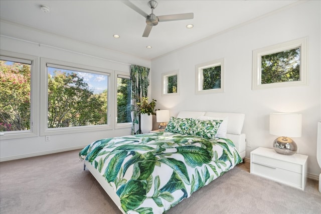 carpeted bedroom with ornamental molding and ceiling fan