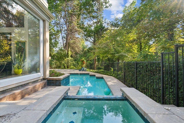 view of swimming pool with an in ground hot tub