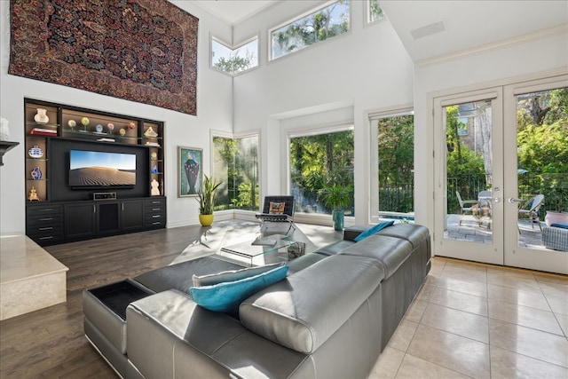 living room with french doors, hardwood / wood-style flooring, a healthy amount of sunlight, and a high ceiling