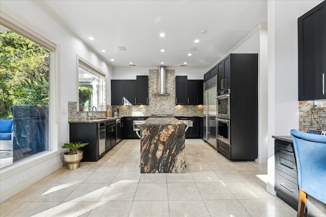 kitchen with ornamental molding, sink, wall chimney range hood, and tasteful backsplash