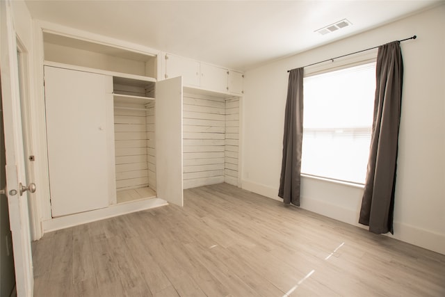 unfurnished bedroom with a closet and light hardwood / wood-style flooring