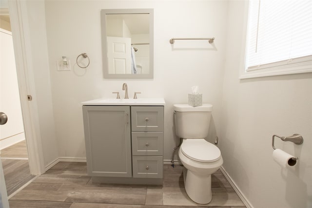 bathroom featuring toilet, vanity, and hardwood / wood-style flooring