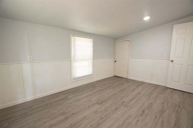 empty room featuring light hardwood / wood-style floors and lofted ceiling