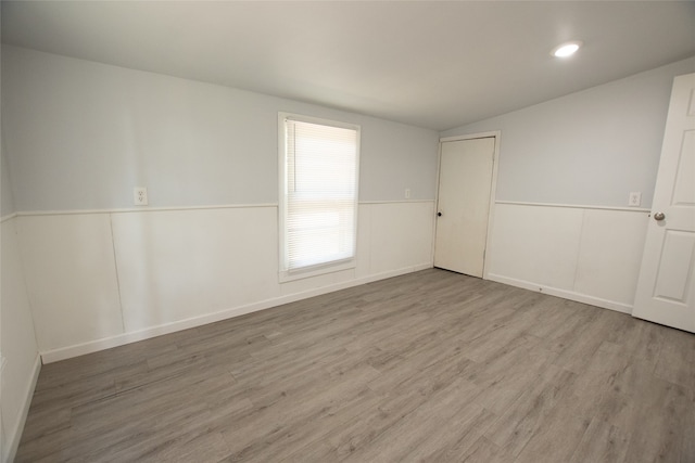 unfurnished room featuring vaulted ceiling and hardwood / wood-style flooring