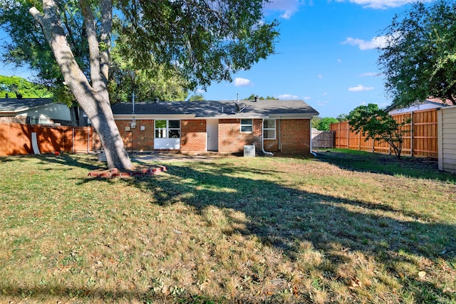 rear view of house with a yard and central AC unit