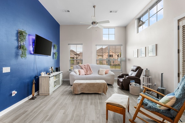 interior space with a towering ceiling, light hardwood / wood-style flooring, and ceiling fan