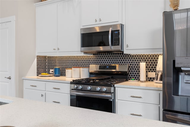 kitchen featuring stainless steel appliances, white cabinets, and tasteful backsplash