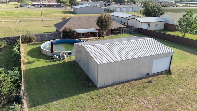 view of pool with a lawn and an outbuilding