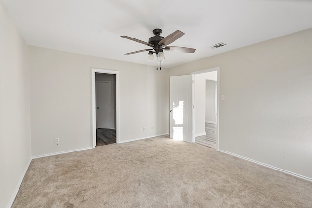 spare room with light colored carpet and ceiling fan