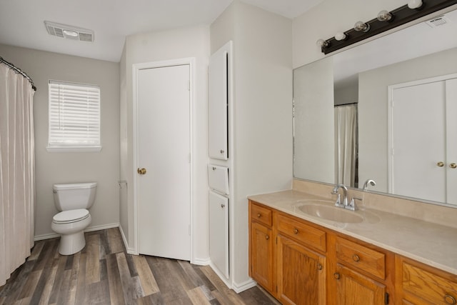 bathroom with vanity, toilet, and wood-type flooring