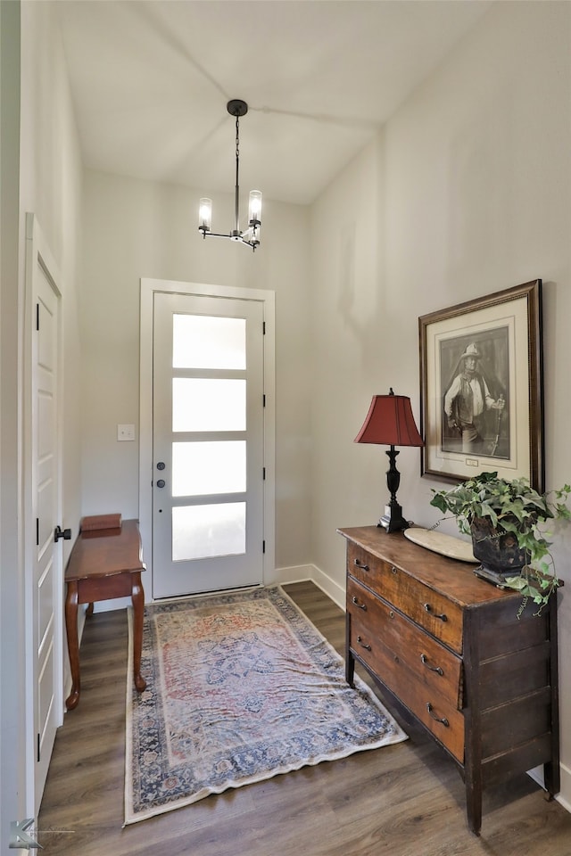 doorway to outside with a chandelier and dark hardwood / wood-style flooring