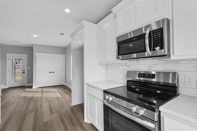 kitchen with white cabinets, stainless steel appliances, and dark wood-type flooring