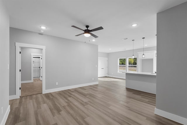 unfurnished living room featuring light hardwood / wood-style floors and ceiling fan