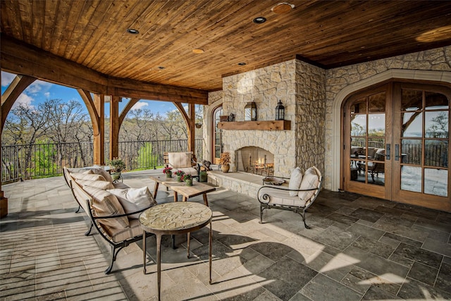3801 Dugas Rd, Aubrey, TX 76227 - view of patio / terrace with fence, an outdoor living space with a fireplace, and french doors
