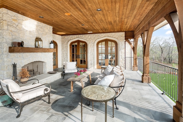 view of patio with french doors and an outdoor stone fireplace