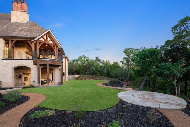 view of yard with a patio and a balcony