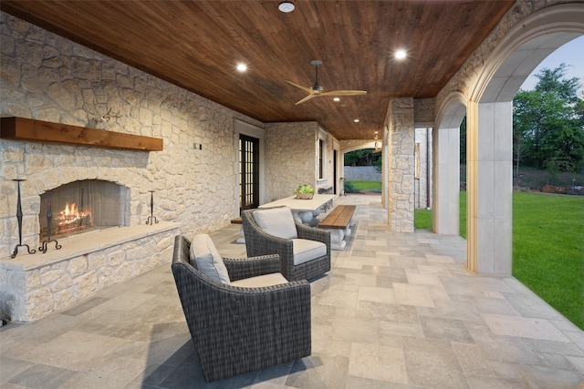 view of patio with an outdoor stone fireplace and ceiling fan